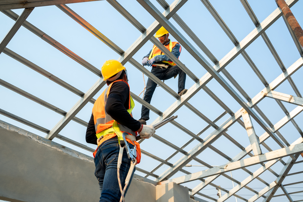 Roofer,builder,worker,attach,metal,sheet,to,new,roof,on